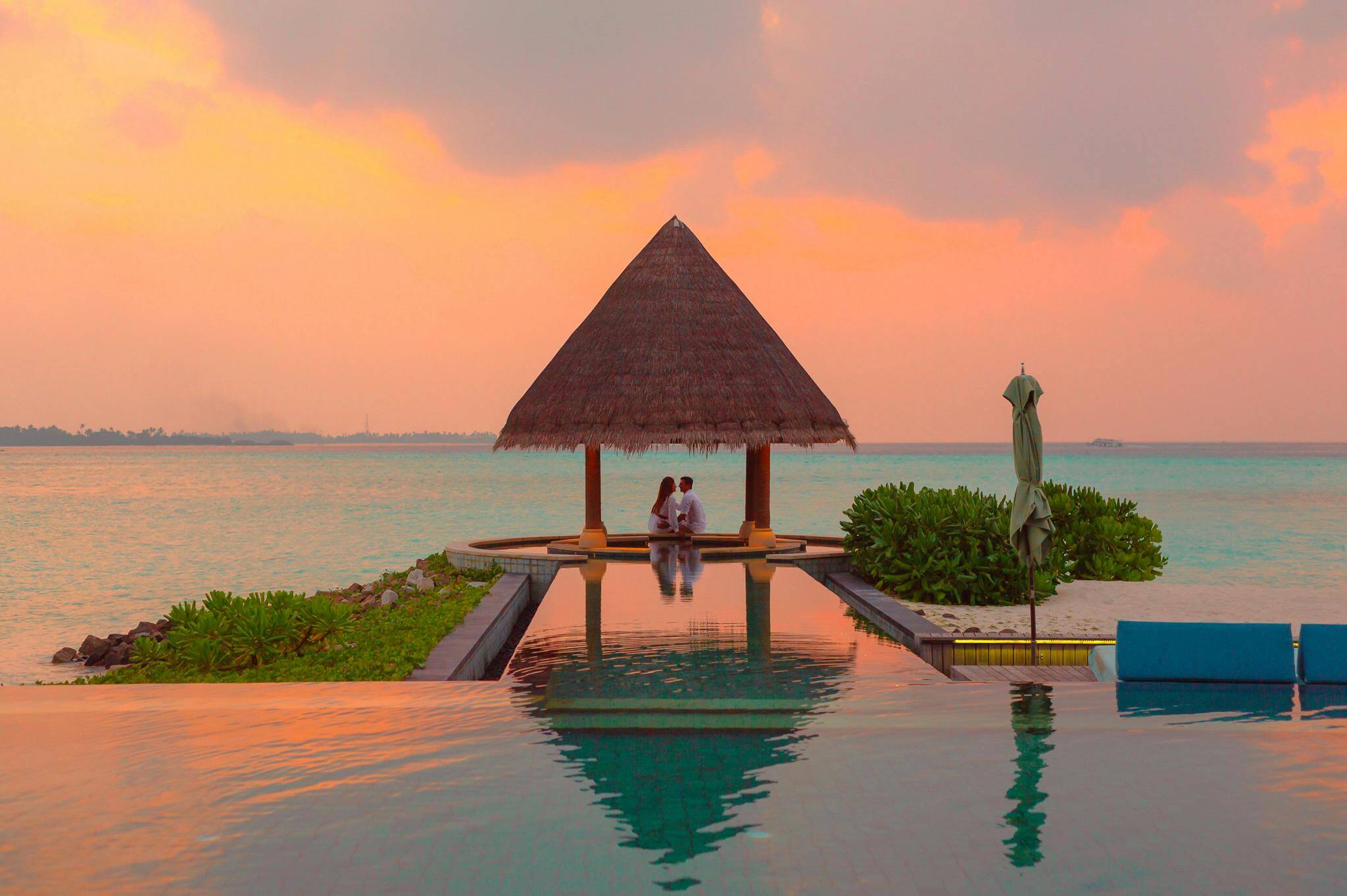 couple under palapa by the ocean and infinity pool. Best caribbean resort for couples post