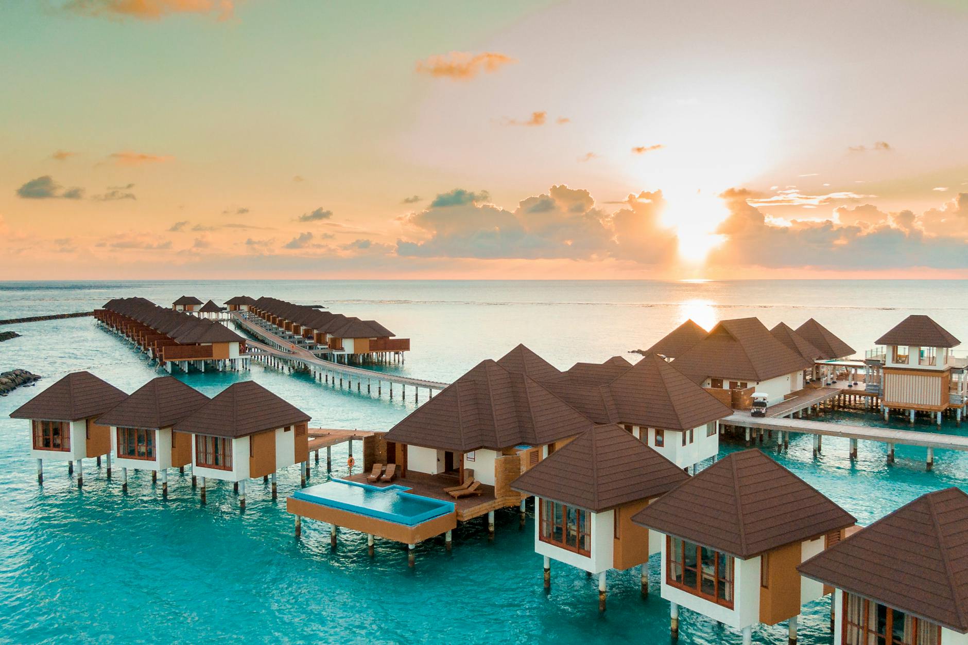 brown and white wooden houses on body of water during sunset, best resorts in the caribbean for a vow renewal or anniversary