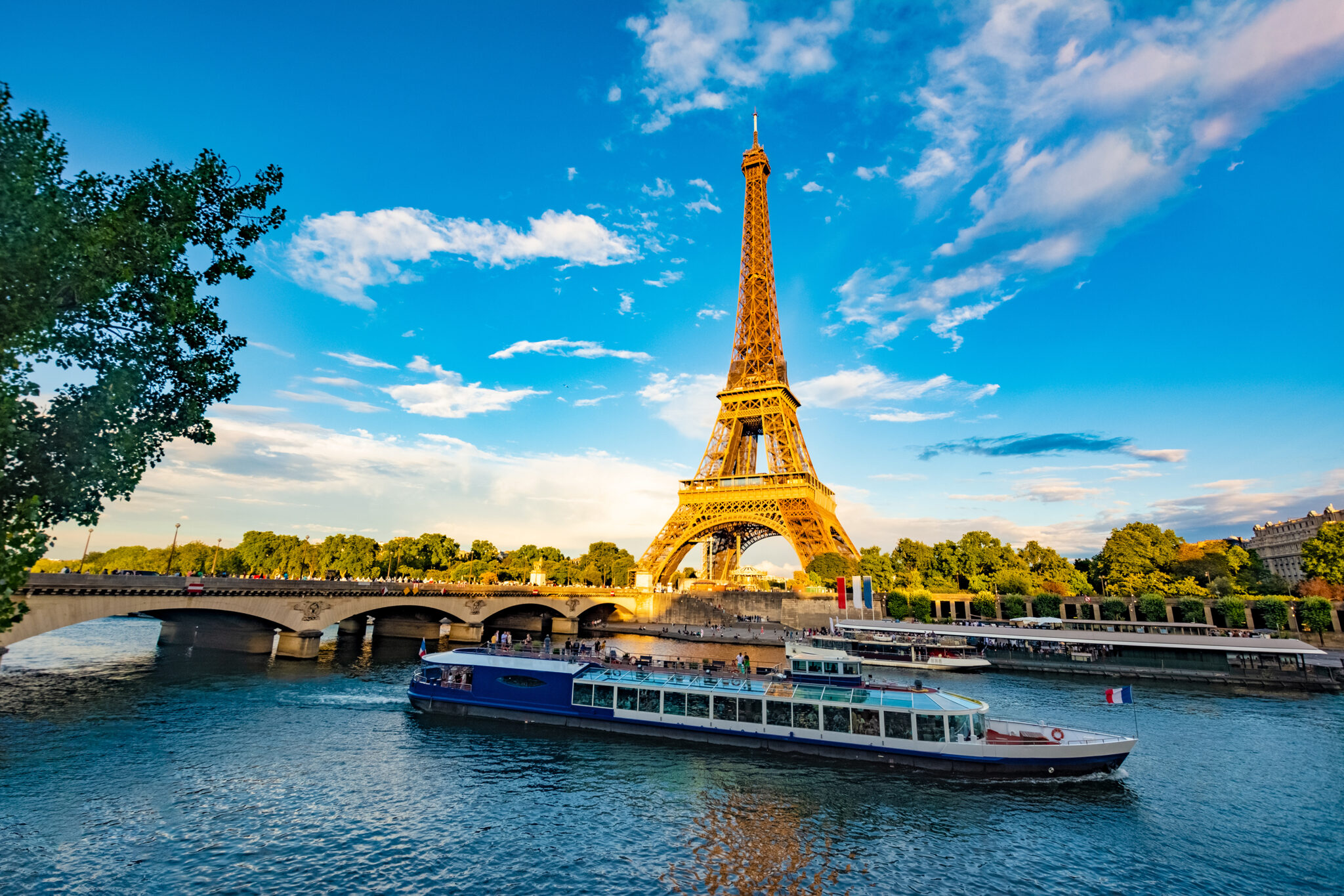 Eiffel Tower in the background of a river cruise ship sailing by