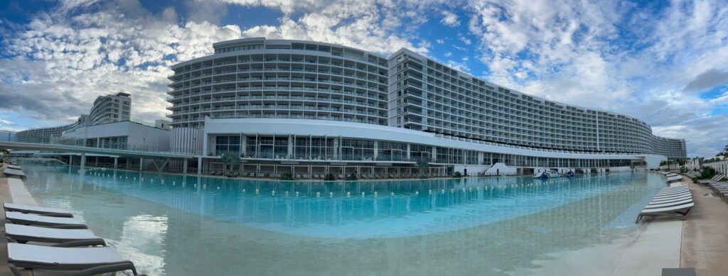 high rise resort with pool surrounding it; from blog post all inclusive resort corporate retreat at Ava Cancun