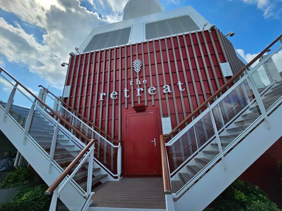 red sign that says Retreat on Celebrity cruise lines from blog post Celebrity vs Virgin Voyages