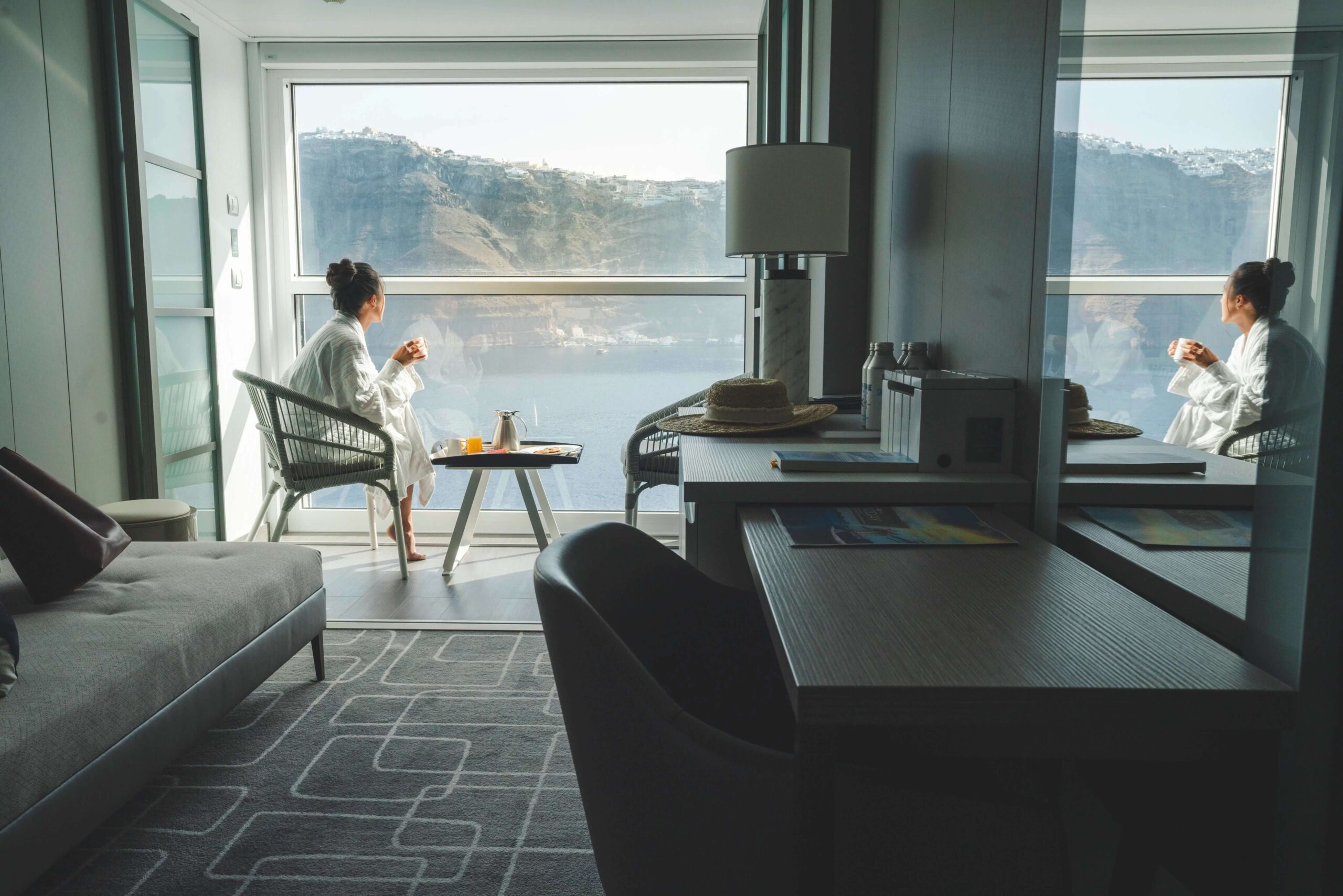 picture of woman sitting on cruise ship balcony with coffee and a robe on, from blog post soft travel for busy professionals
