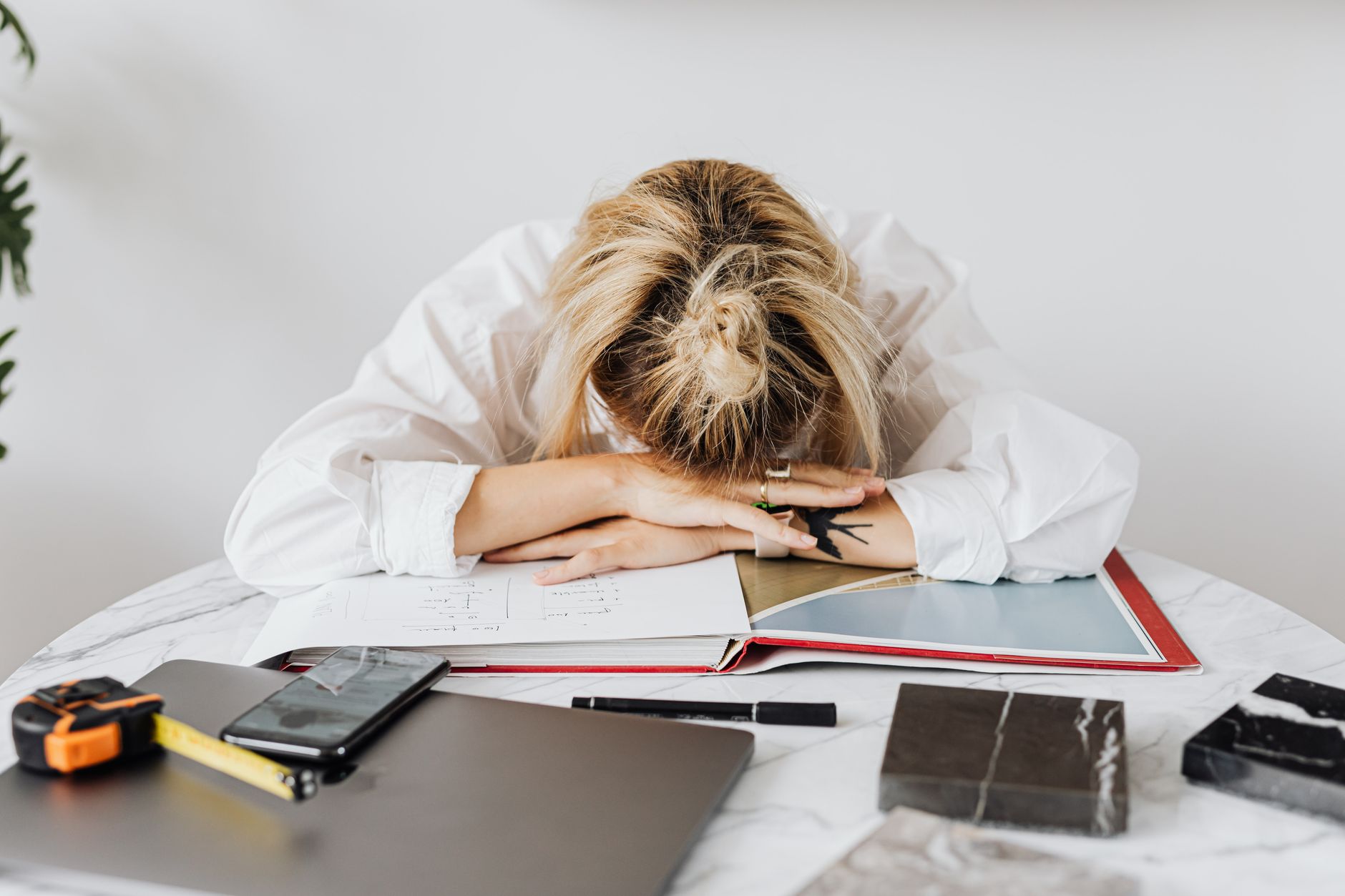 photograph of an exhausted woman in a white shirt