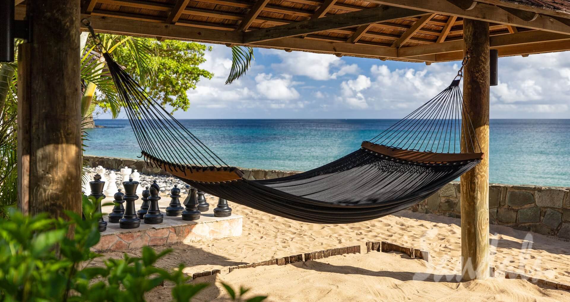 hammock on the beach with the blue waters in the background